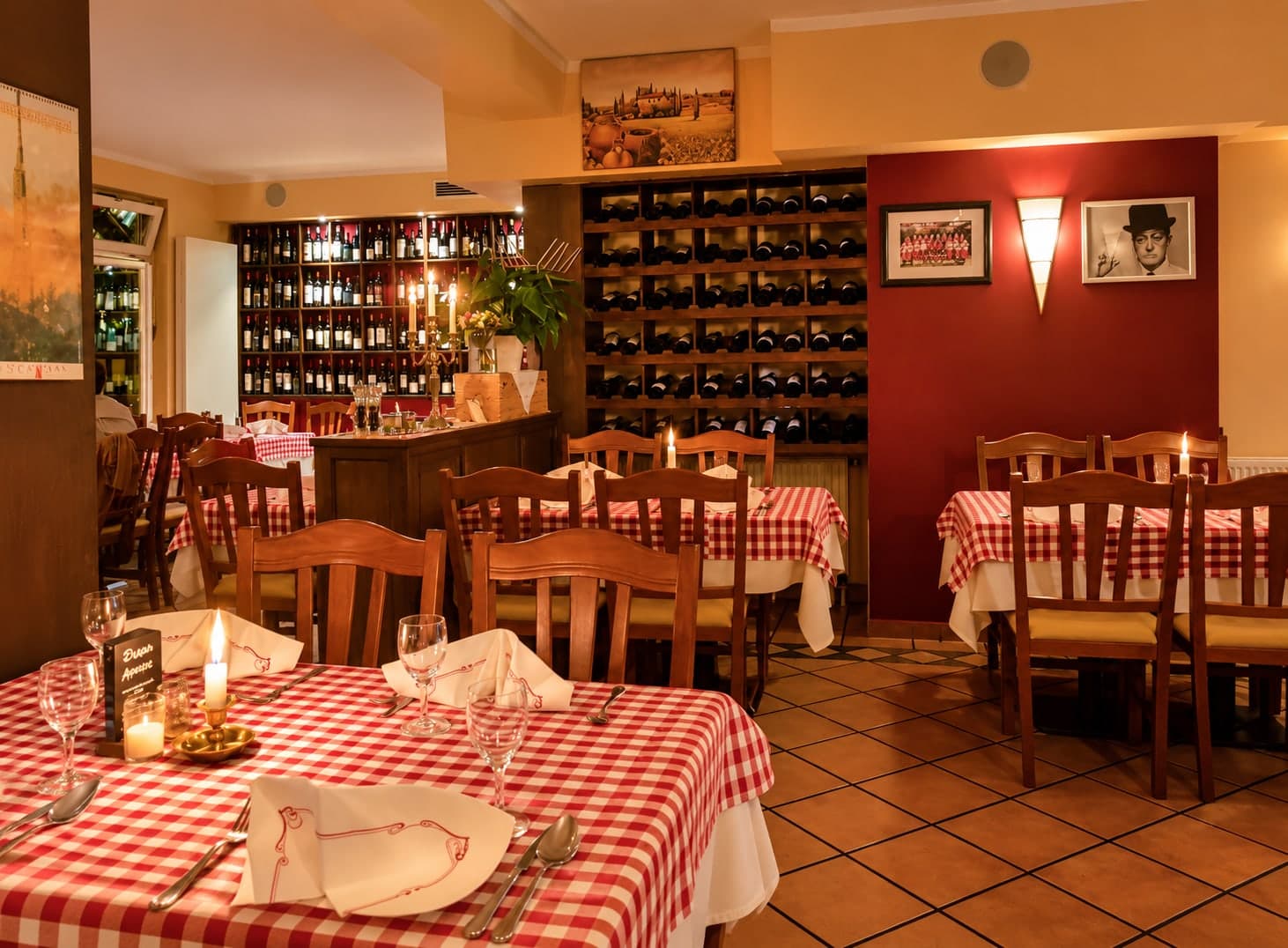 Laid tables with red-and-white checked cloths in the dining room of AL Dente
