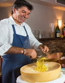 Mario tossing pasta in a wheel of Parmesan